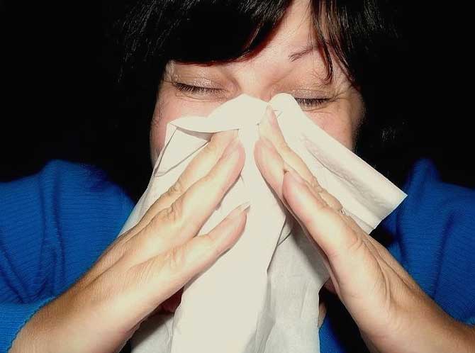 Woman sneezes