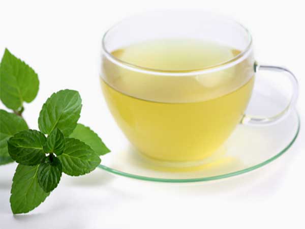 a sprig of mint beside a cup of mint tea