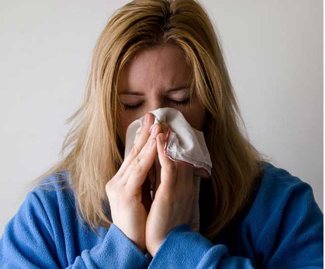 Woman blows her nose into a handkerchief