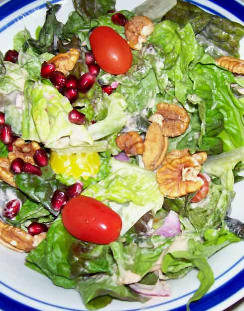 Vegetable salad with lettuce, spinach, tomatoes, and pecans